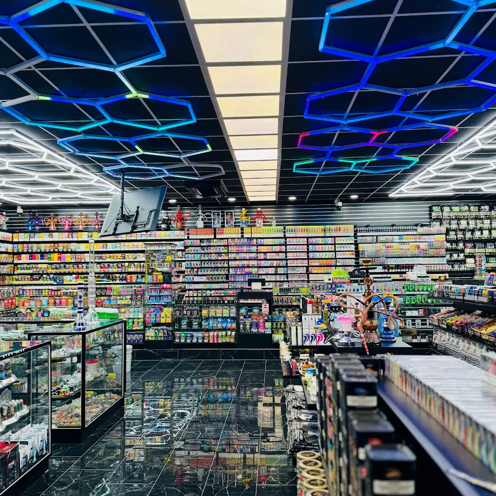 Wide interior of EZ Smoke House Hampton VA with hex neon ceiling, full vape wall and hookah counter